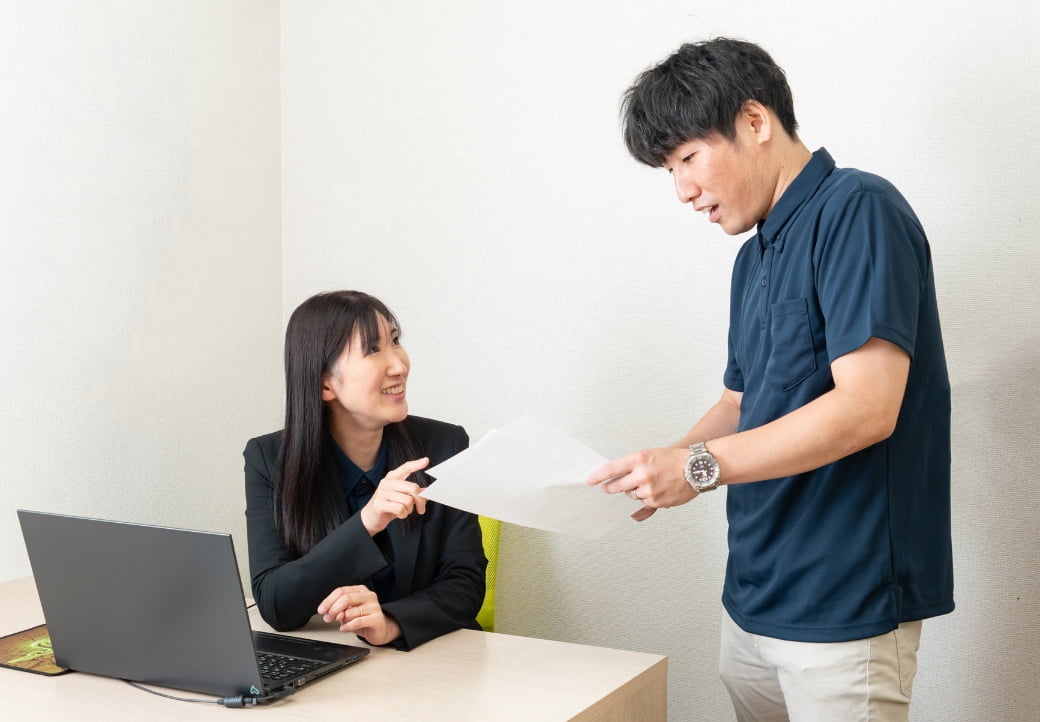 書類を見て会話するスタッフ